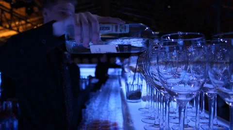 Blue bar glasses bartender pours from a bottle Stock Footage 4575733