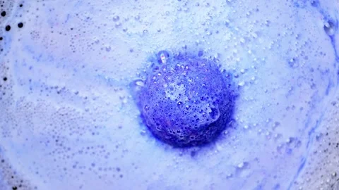 Blue bath bomb ball dissolves in water with foam bubbles. Stock Footage 274444573