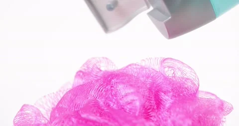 Blue bath soap gel is squeezed onto a pink shower pouf Stock Footage 144289806
