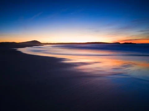 Blue beach at dusk Stock Photos