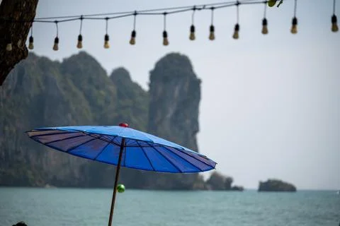 Blue beach umbrella with limestone cliffs in Ao Nang Photos
