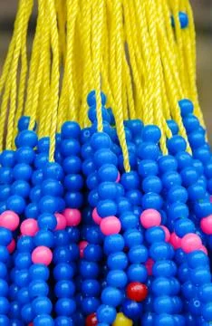 Blue beads and yellow string hanged on wall. Turkish souvenir. Stock Photos
