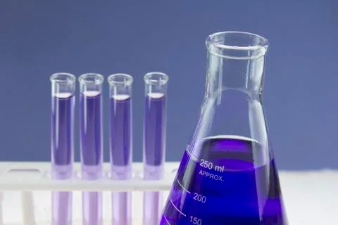 Blue beaker and test tubes Stock Photos