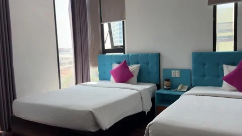Blue bedroom with two beds and bright pink pillows raspberry color thin windows Video stock 307370617