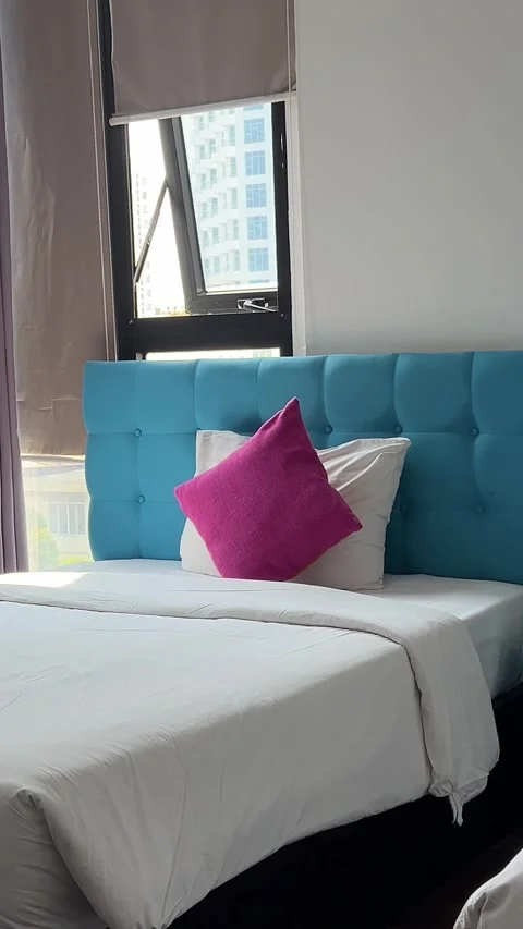 Blue bedroom with two beds and bright pink pillows raspberry color thin windows Stock Footage 309268251