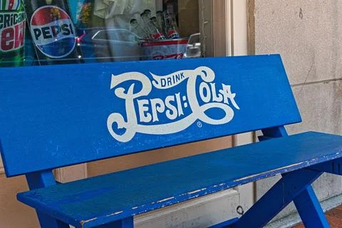 A Blue Bench with Pepsi Cola Fotos de archivo