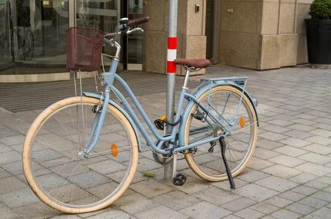 Blue bicycle parked on sidewalk. Stock Photos