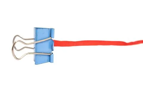 Blue Binder Clip Securing a Red Ribbon Against a White Background Stock Photos