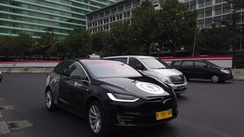 Blue Bird Tesla Model X 75D e-Taxi Passing Through Bundaran HI Stock Footage 132069217
