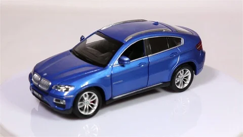 Blue BMW X6 scale model suv car is rotating isolated on white background. Stock Footage 102021636