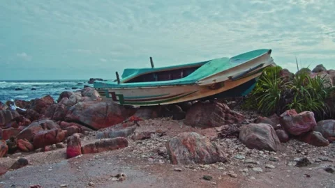 Blue boat on the rocks on the beach Stock Footage 241833889