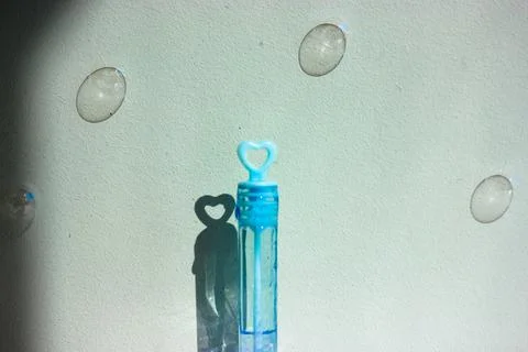 Blue bottle of soap bubbles on blue background. Soap bubbles flying in the air Stock Photos