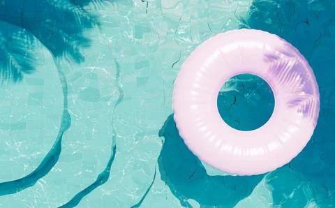 Blue bottom pool with a pink float and palm trees Stock Photos
