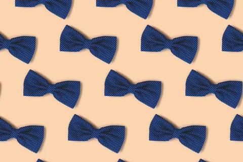 Blue bow ties repetitive pattern on a beige background. Stock Photos