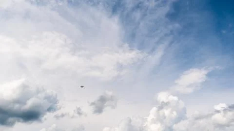Blue bright sky with clouds and small plane Stock Photos