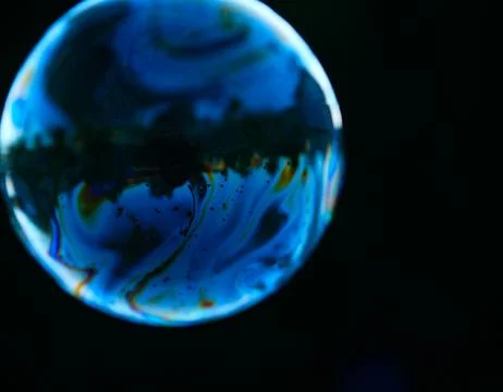 Blue bubble with abstract pattern isolated on a dark background. Stock Photos