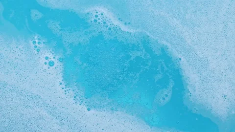 Blue bubbling liquid boiling texture. Bomb ball dissolves in water with white Stock Footage 163680060