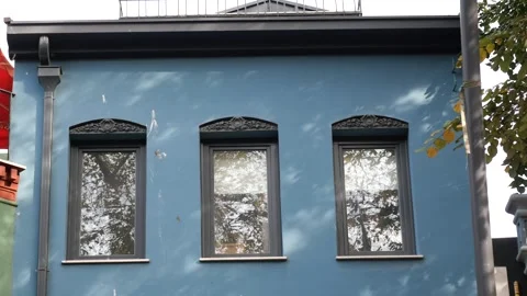 Blue building with three windows under a cloudy sky Stock Footage 325067414