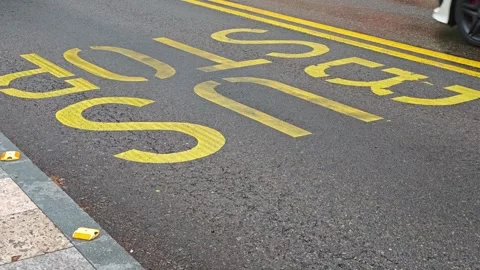 Blue bus arriving at bus stop sign painted on asphalt 库存影片 308035944