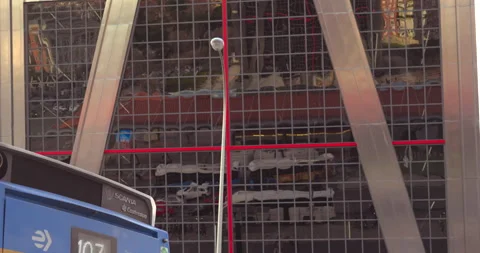 A blue bus is parked in front of a tall building Stock Footage 327320377