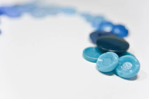 Blue buttons of different shape and size on the white background. Selective f Stock Photos