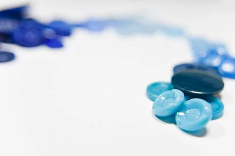 Blue buttons of different shape and size on the white background. Selective f Stock Photos