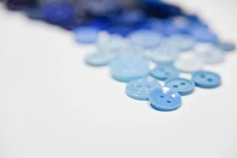 Blue buttons of different shape and size on the white background. Selective f Stock Photos