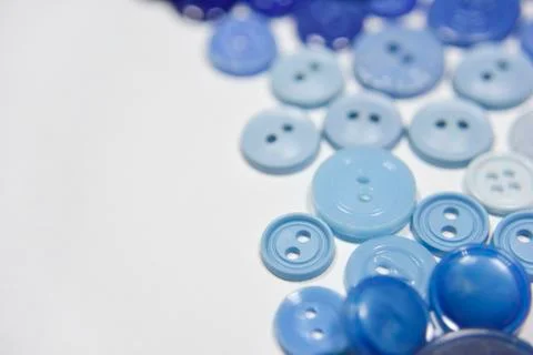 Blue buttons of different shape and size on the white background. Selective f Stock Photos
