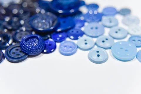 Blue buttons of different shape and size on the white background. Selective f Stock Photos
