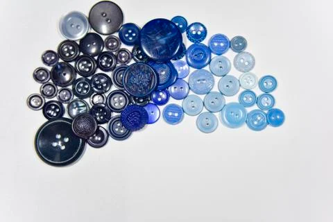 Blue buttons of different shape and size on the white background. Selective f Stock Photos