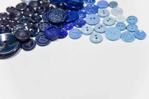 Blue buttons of different shape and size on the white background. Selective f Stock Photos
