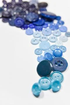 Blue buttons of different shape and size on the white background. Selective f Stock Photos