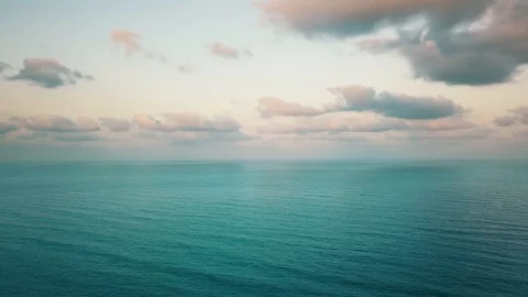 Blue calming waves of Ocean during sunset with a cloudy sky. 4k Video Stock Footage 126570547