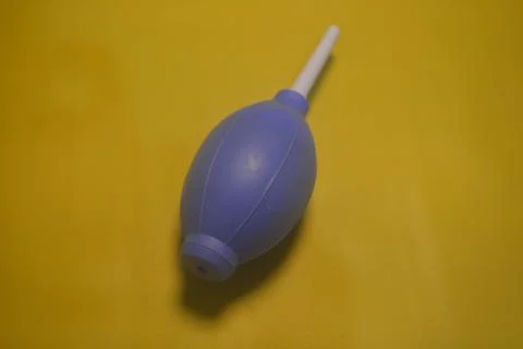 Blue camera lens blower, camera cleaning tool, isolated on yellow background Stock Photos
