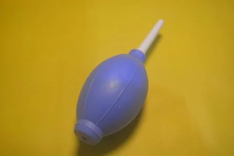 Blue camera lens blower, camera cleaning tool, isolated on yellow background Stock Photos