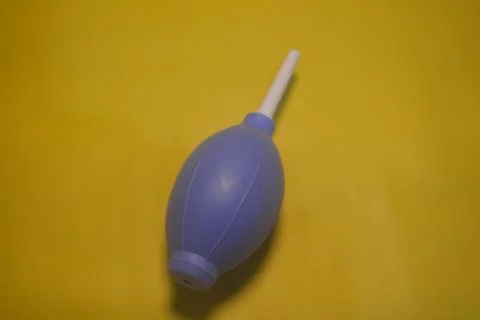 Blue camera lens blower, camera cleaning tool, isolated on yellow background Stock Photos