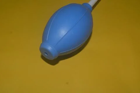 Blue camera lens blower, camera cleaning tool, isolated on yellow background Stock Photos