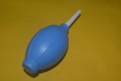 Blue camera lens blower, camera cleaning tool, isolated on yellow background Stock Photos