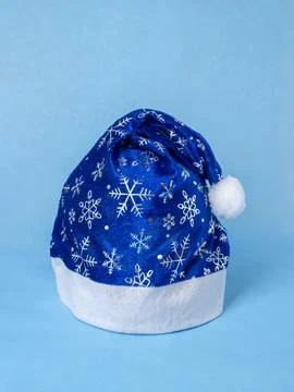 Blue cap with silver pattern of Santa Claus with snowflakes on blue backgroun Stock Photos