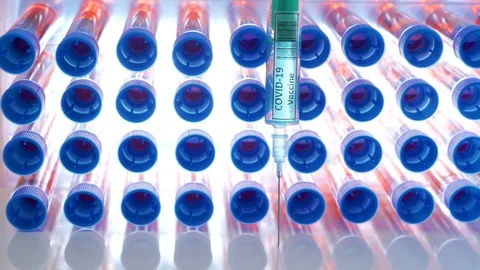The blue cap test tubes with the syringe for coronavirus or Covid-19 vaccine Stock Footage 128406825
