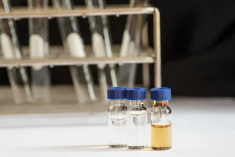Blue cap vial in front of Laboratory glassware Stock Photos