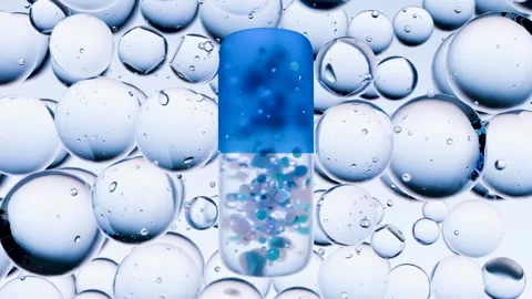Blue Capsule Pill with Micro Particles Surrounded by Transparent Bubbles Stock Footage 315214326