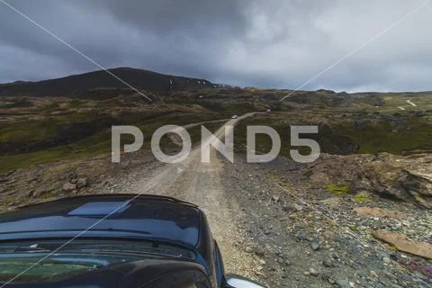 Blue car driving in highlands Iceland view over the car hood Stock Photos