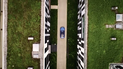 Blue car driving through modern sustainable architecture Stock Footage 330770190