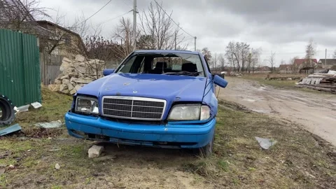 A blue car hit by shells. A car destroyed by an explosion in Ukraine Stock Footage 271029697
