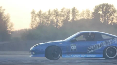 Blue car loses control and spins out while drift racing around corner. Stock-Footage 59762063