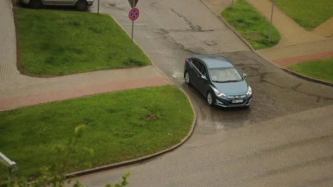 A blue car is turning down a wet city street after rain. Stock Footage 336868843