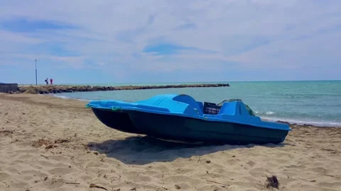 A blue catamaran pulled ashore lies on the sand. Sandy sea beach Stock Footage 248245392