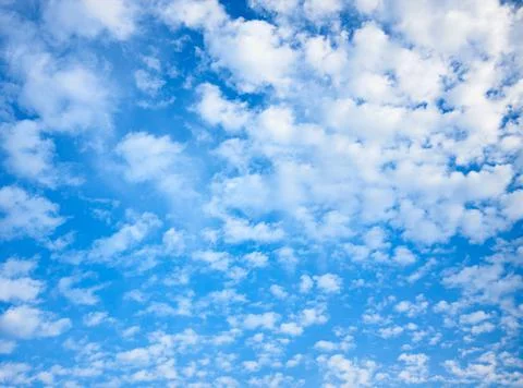 Blue celestial background with white fleecy clouds Stock Photos
