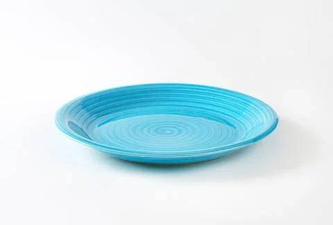 Blue ceramic dinner plate on plain background Stock Photos
